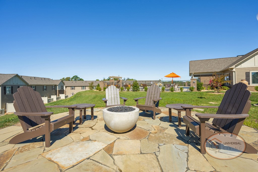 A fire pit wit chairs.