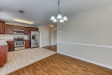 A kitchen with wooden cabinets and a tile floor.