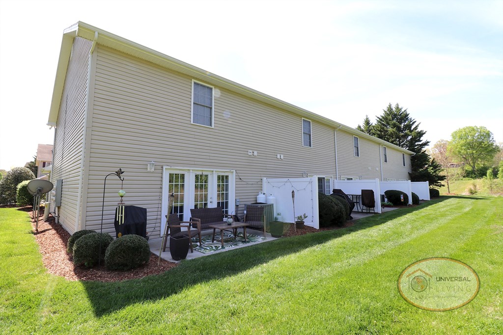 A large tan and white apartment building with large patio doors.