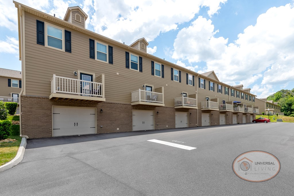 Two bedroom Apartment Homes with balconies, garages, and tan siding.