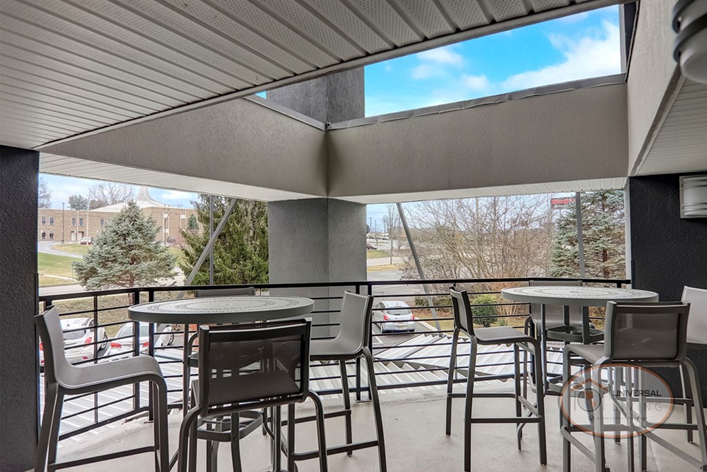 a patio with tables and chairs and a view of a building