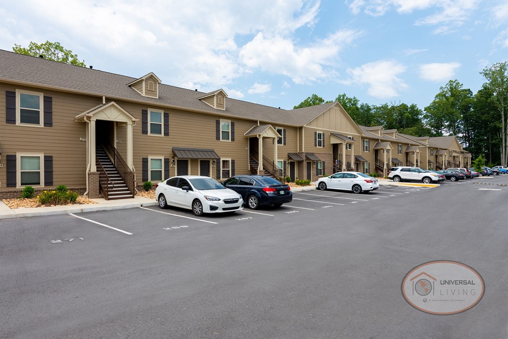 a parking lot in front of a building with cars parked in front