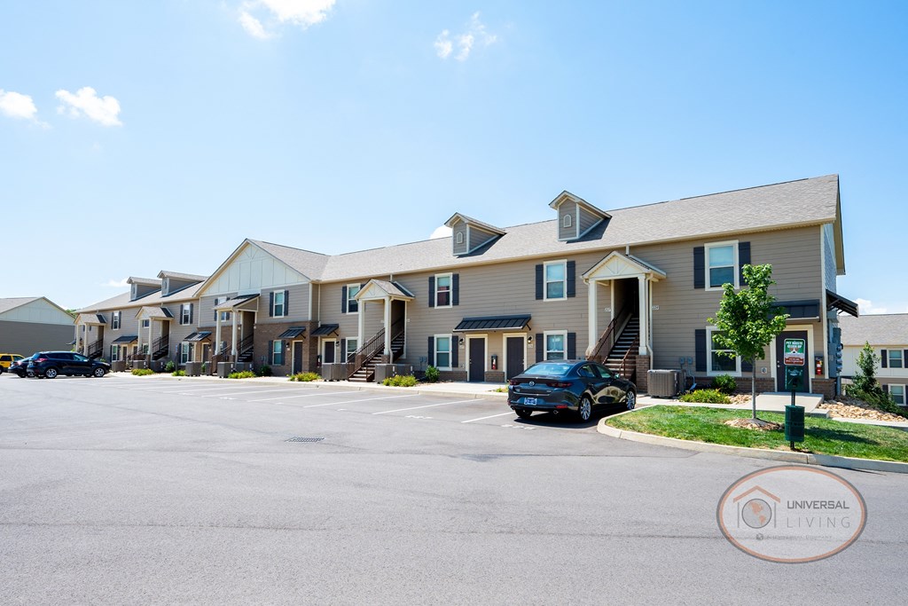 a row of apartment buildings with cars parked in front of them