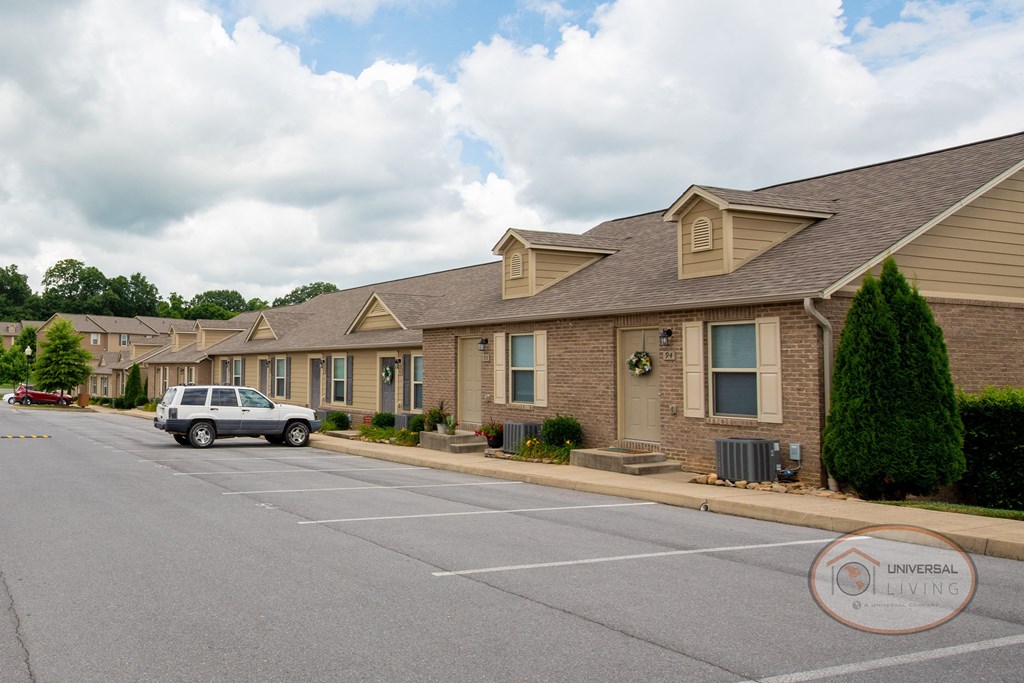 A row of tan apartment buildings with brick accents.