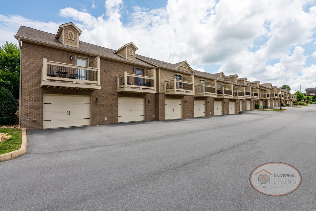 A row of tan apartments with drive under garages.
