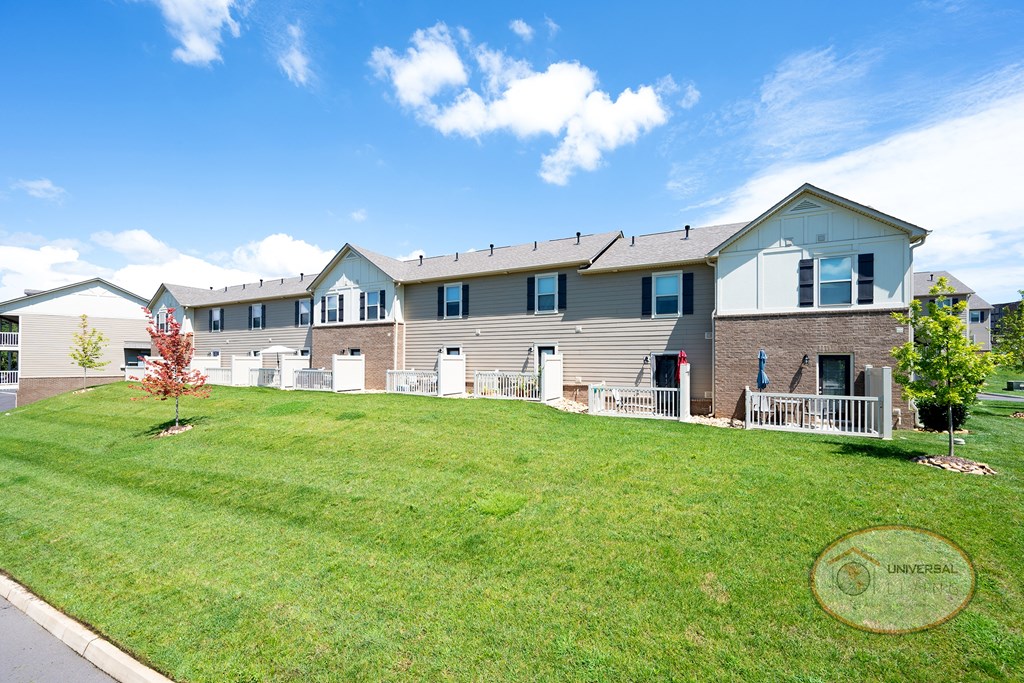 an apartment building with a lawn in front of it