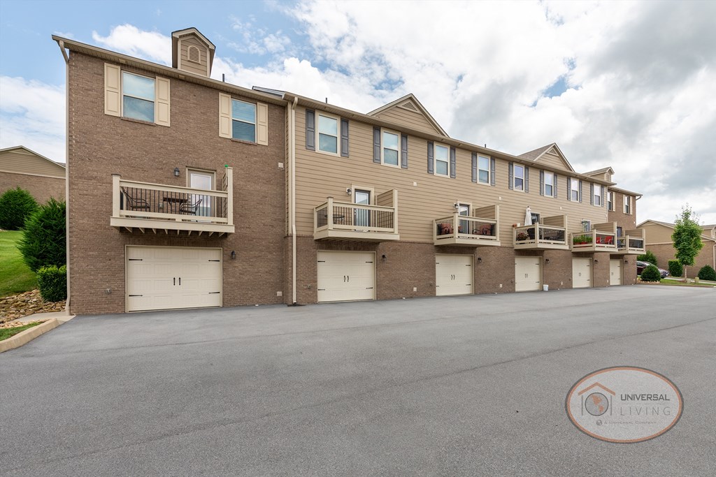 an empty parking lot in front of a brick apartment building
