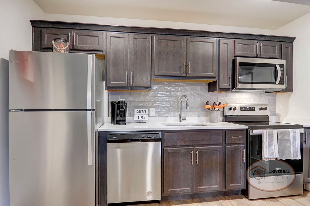 a kitchen with stainless steel appliances and dark wood cabinets