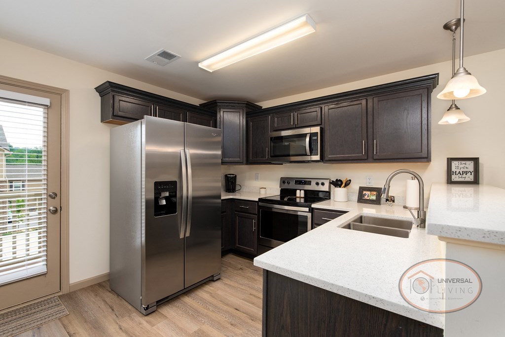 an updated kitchen with stainless steel appliances and white countertops