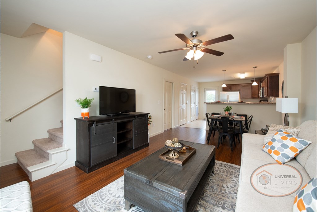 A living room with a couch and a table and a ceiling fan.