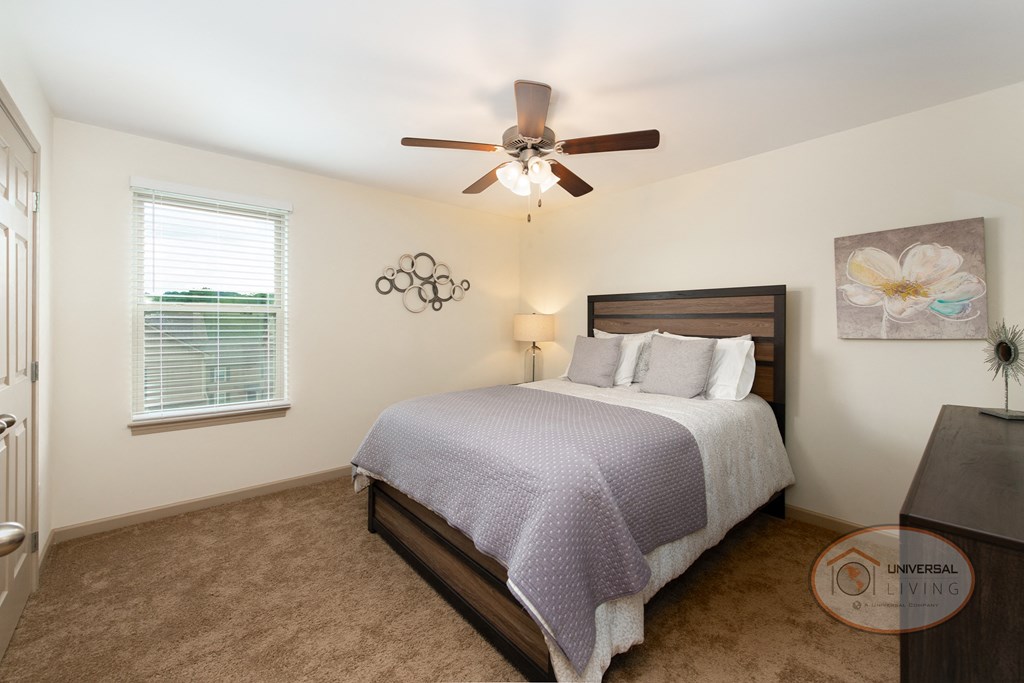 a bedroom with a bed and a ceiling fan