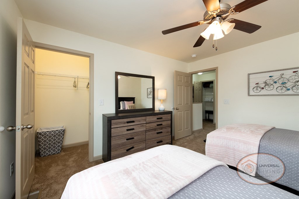 a bedroom with two beds and a ceiling fan