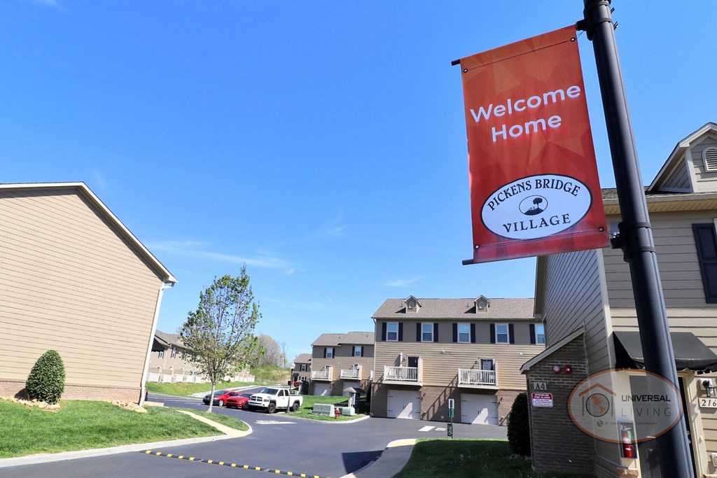 An orange banner reading "welcome home" hangs before a view of the property.