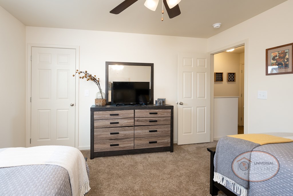 A bedroom with a bed, dresser, and mirror.