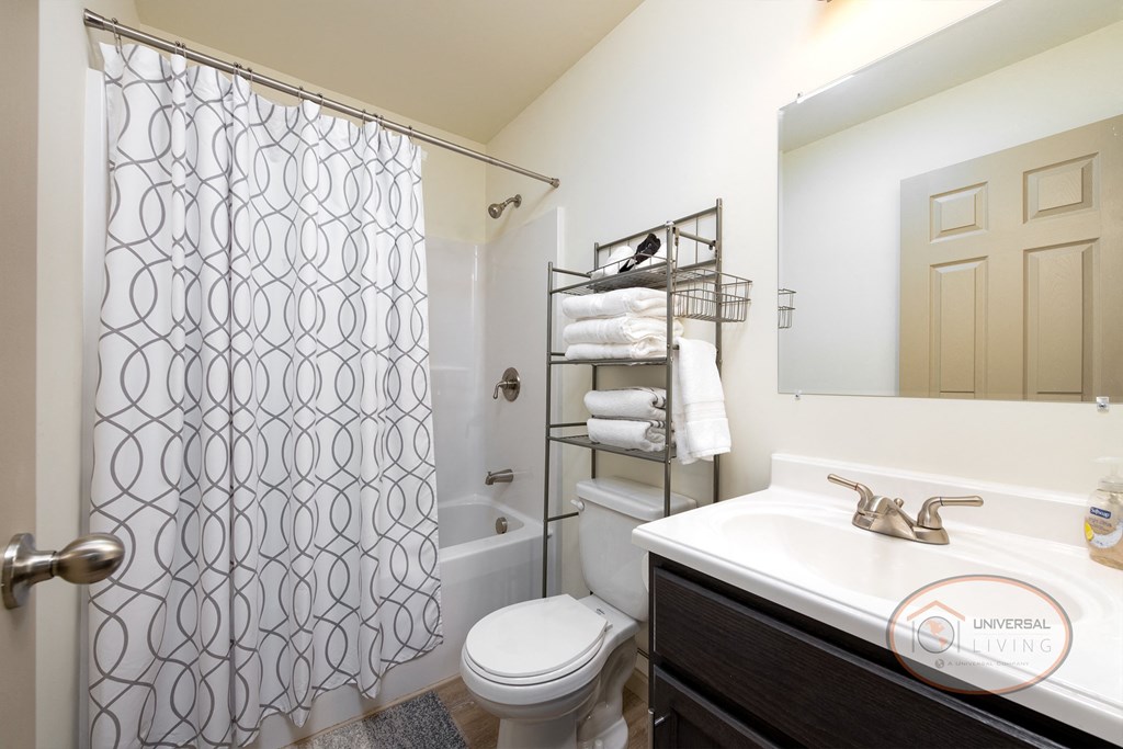 a bathroom with a shower and a sink and a toilet