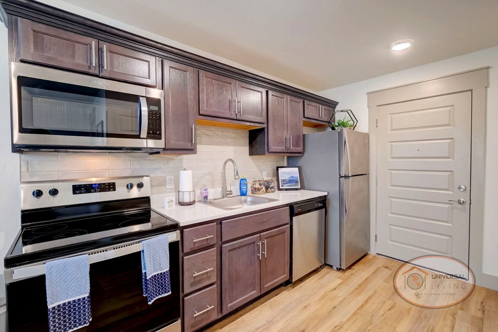 A studio apartment kitchen with stainless steel appliances.