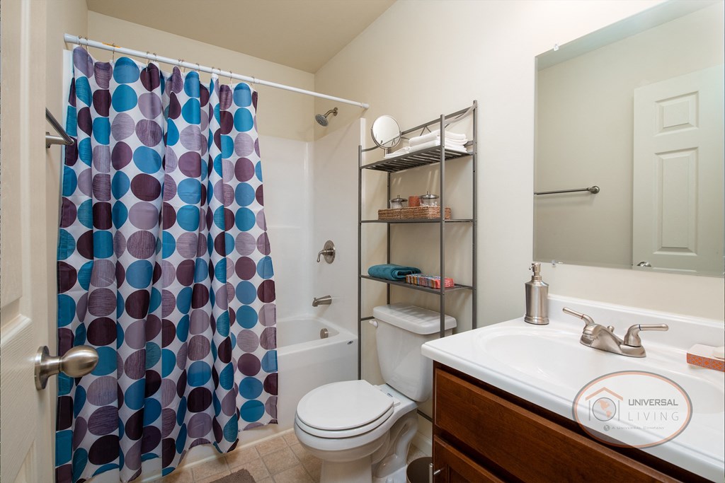 A bathroom with dark cabinets and white walls.