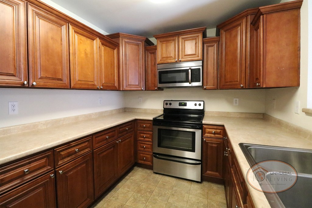 A kitchen with wooden cabinets and stainless steel appliances.