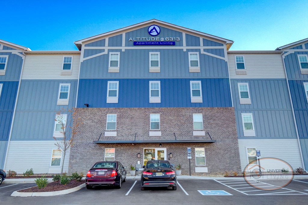 Altitude @ 6313, Apartment homes for rent in Knoxville, Tennessee. Exterior view of a grey and blue apartment home complex with ample parking.