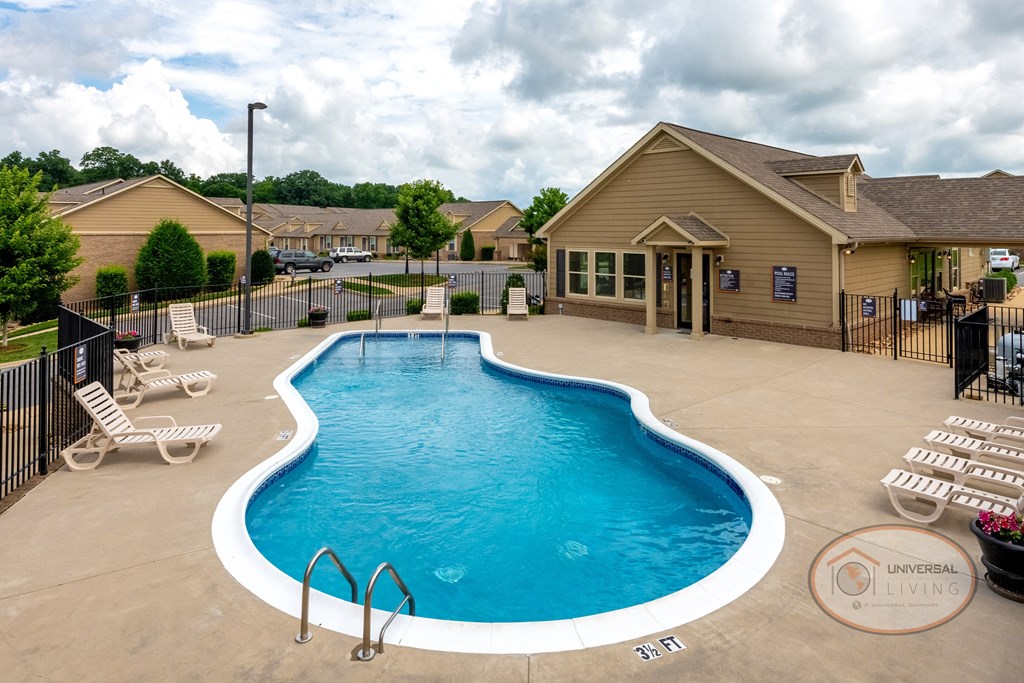 our resort style swimming pool is next to our house with lounge chairs and tables