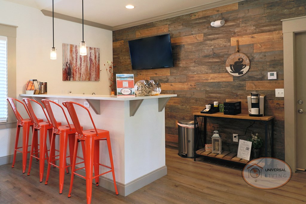 a bar with red stools in front of a wall with a wood accent wall