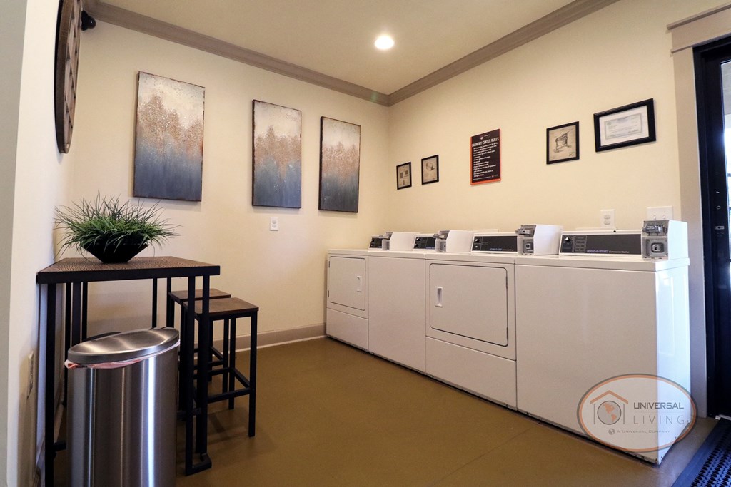 a laundry room with washing machines and a table with stools