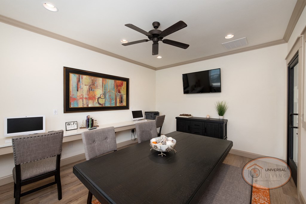 a living room with a large table and a ceiling fan