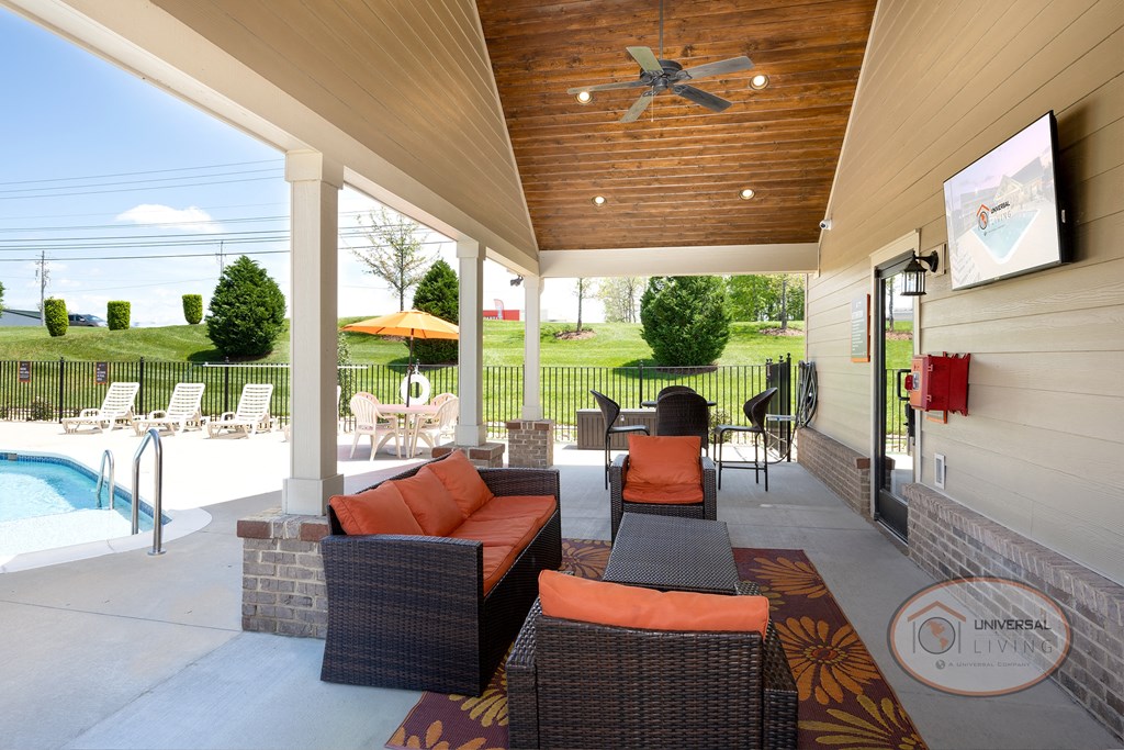 Poolside patio with flat screen TV, fireplace, ceiling fans, and lounge seating