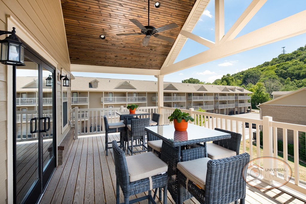 The clubhouse patio with a table and chairs and a ceiling fan.
