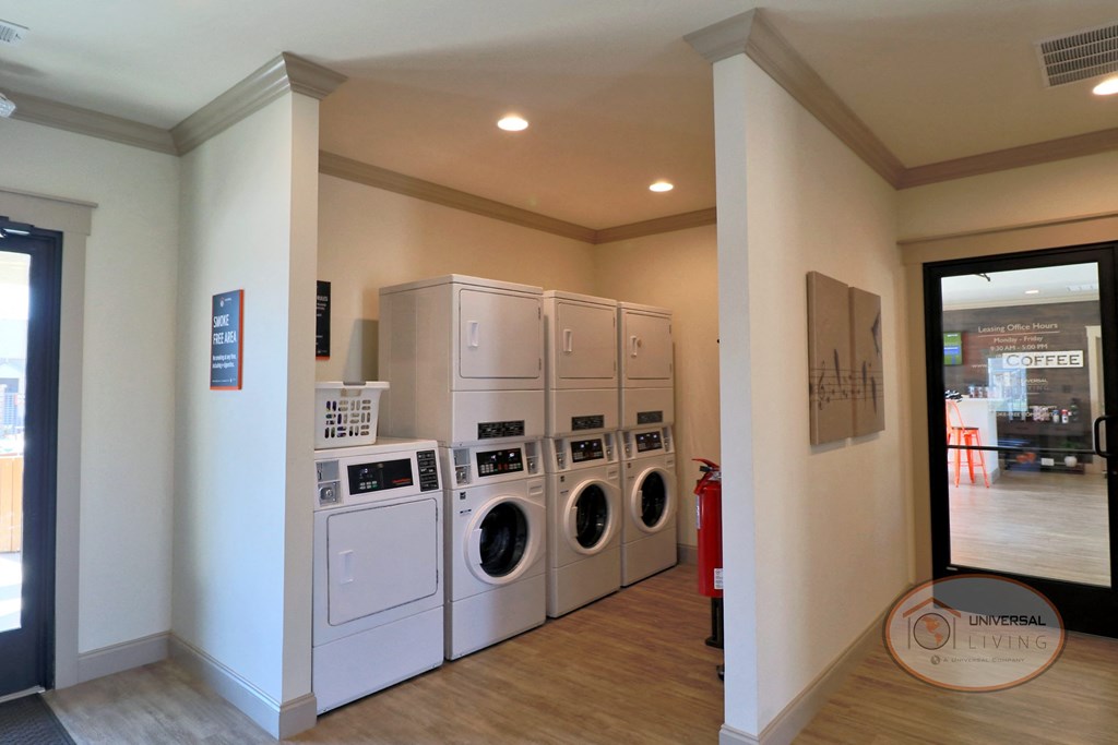A laundry center with washers, dryers, and seating.