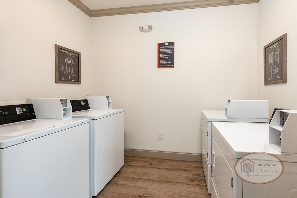 a laundry room with washes and dryers and a sign on the wall