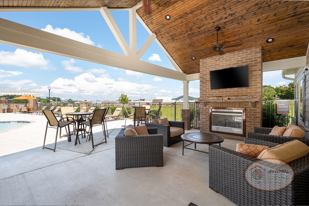Poolside patio with flat screen TV, fireplace, and lounge seating.