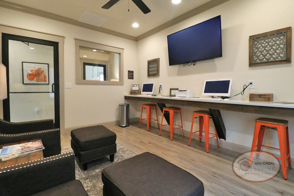 a living room with a bar with stools and a television