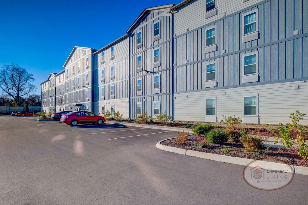 A view of the exterior of the blue and grey apartment building.