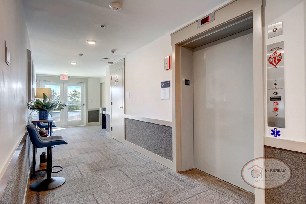 A hallway leading to a lounge area and elevators.