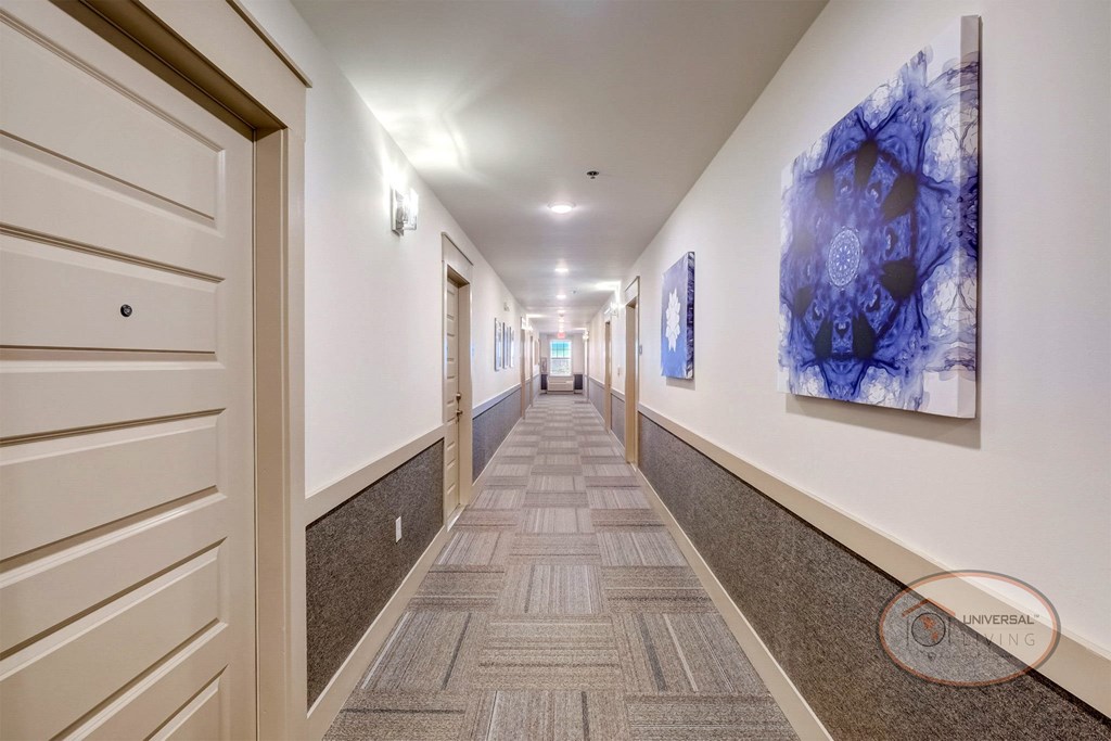 A hallway with blue abstract art leading to apartment homes.
