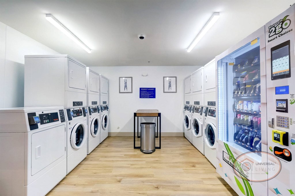 The on-site laundry center with washers, dryers, a table, and a vending machine.