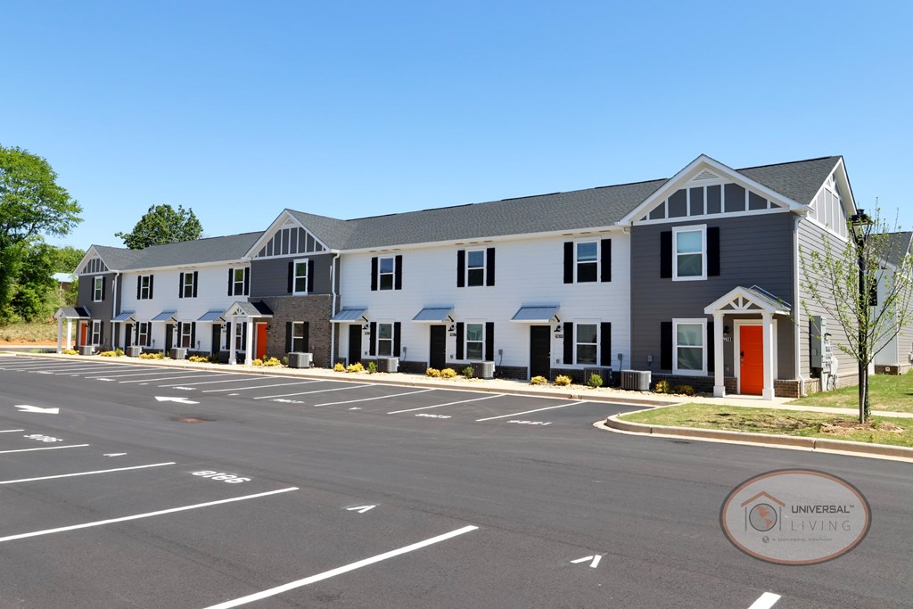 A white and gray apartment building with orange doors.