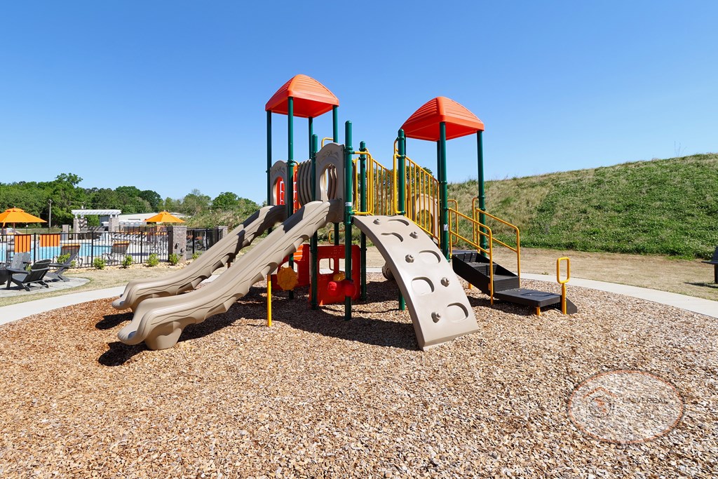 A playground with multi-colored jungle gym and slides.