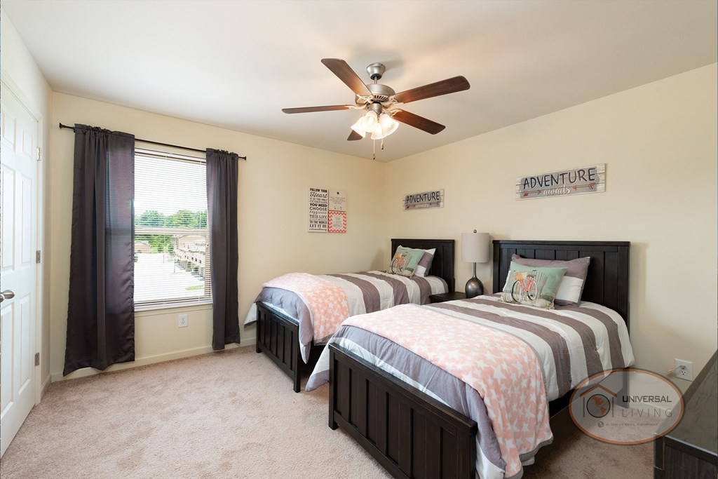 two twin beds in a bedroom with a ceiling fan