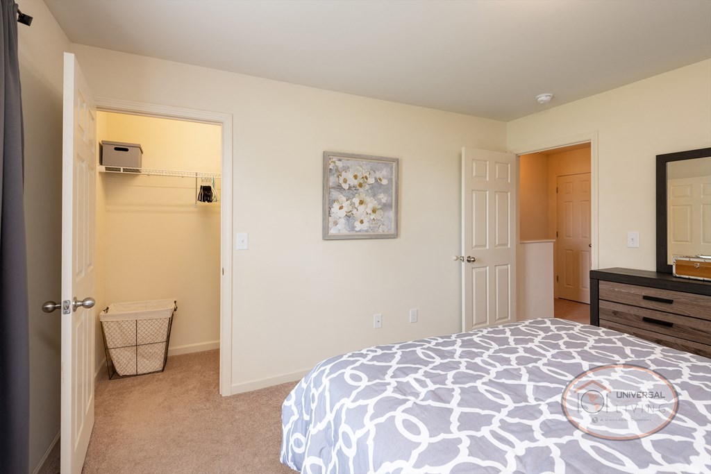 a bedroom with a bed and a closet and a bathroom