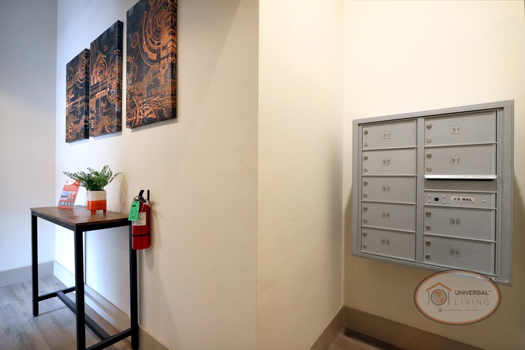 A grey mailbox hanging on the wall in the entry way landing.