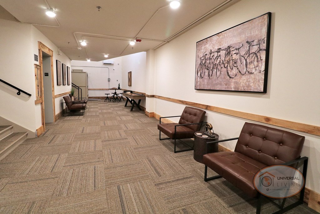 A long hallway full of lounge seating, tables, and games.