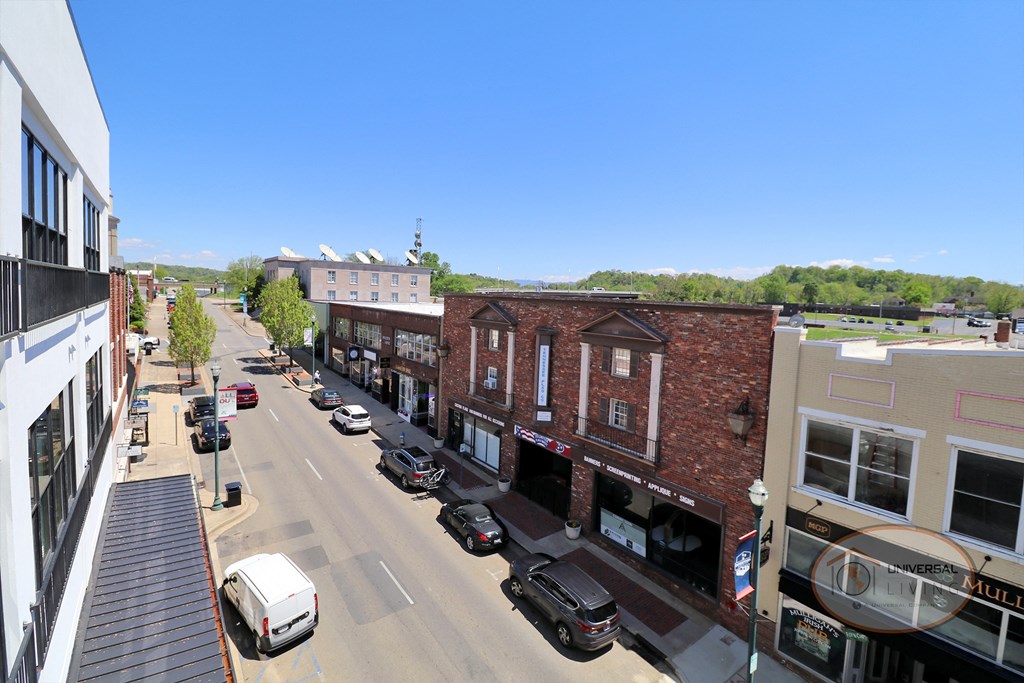 An aerial view of a city street with buildings and cars.