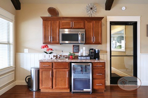 a kitchen with wooden cabinets and a counter with a refrigerator and a microwave
