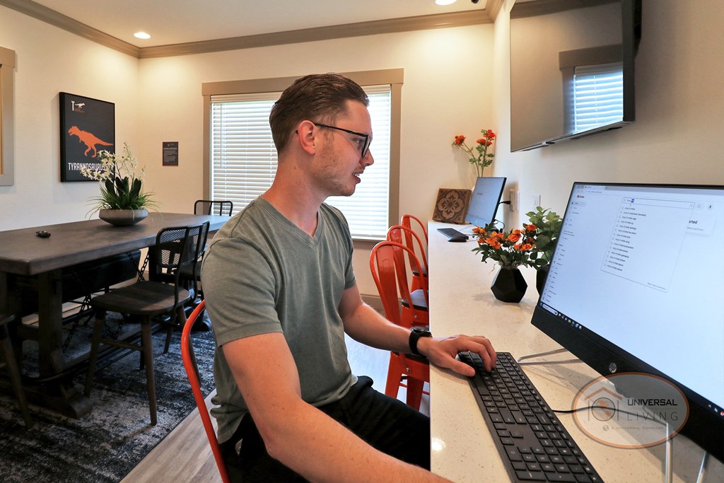 A man sitting at a computer in the business center.