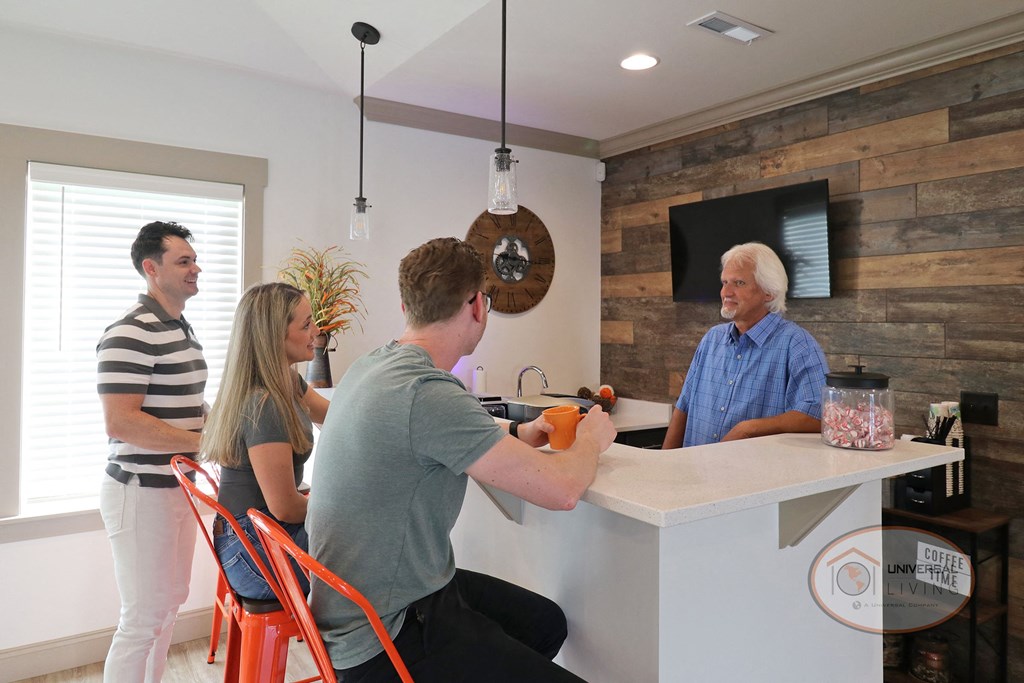 A group of people relaxing around the coffee bar drinking coffee.