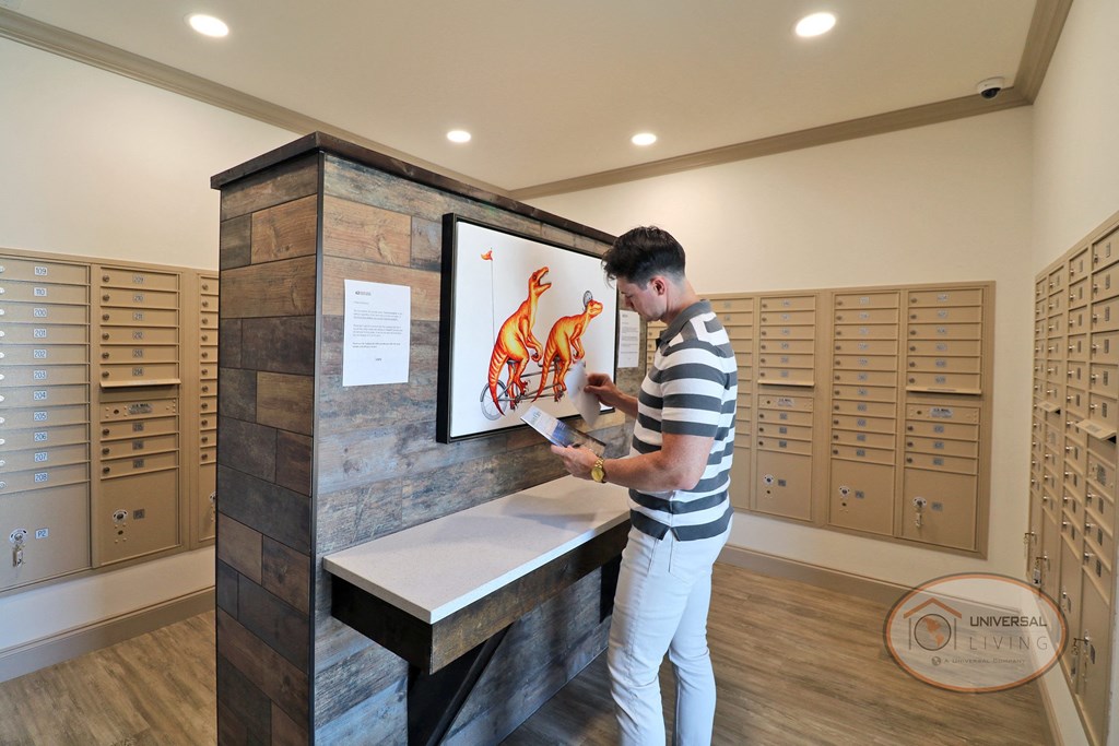 A man sorting through mail at a table in the mail center.