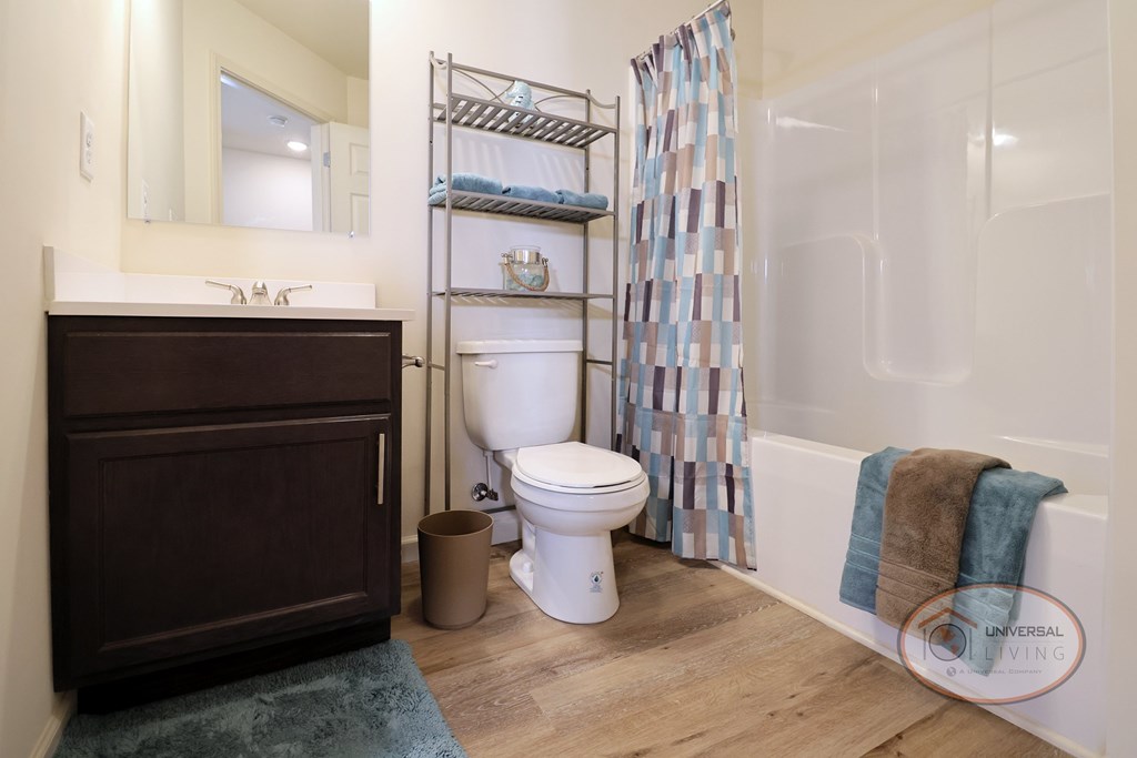 A bathroom with a toilet, sink, and a shower curtain.