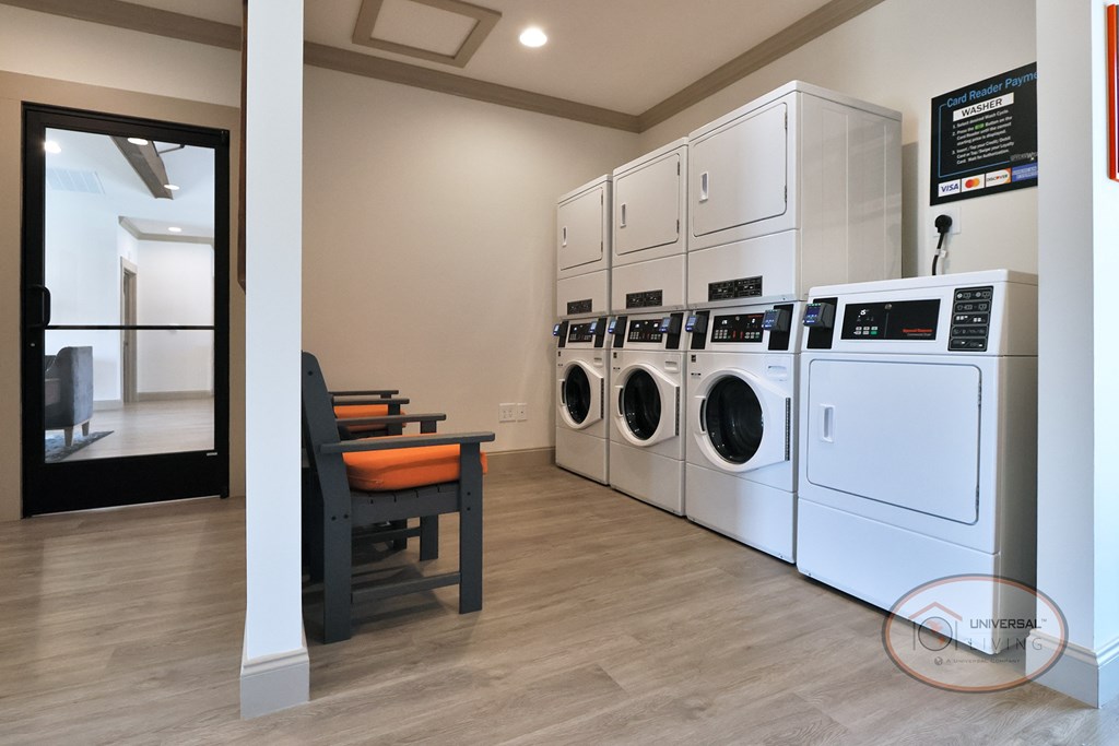 A community laundry center with washers, dryers, and seating.